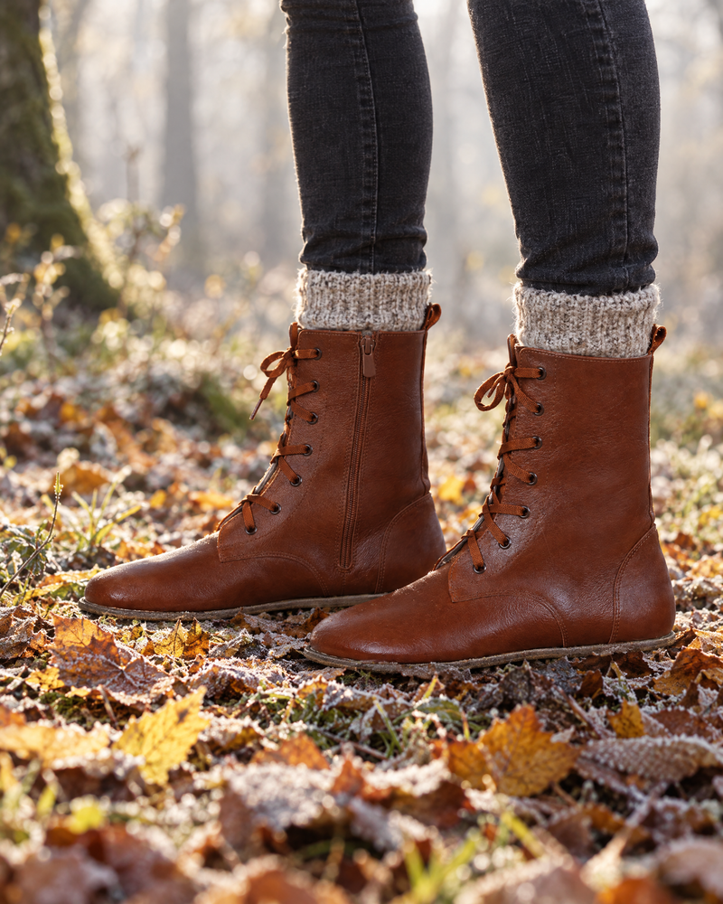 Barefoot leather boots on autumn leaves